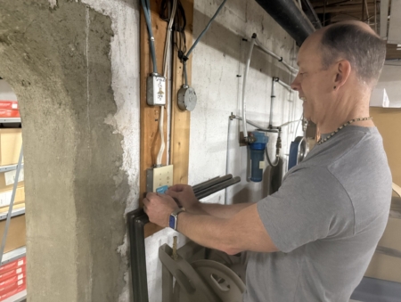 Cowan's Office Supplies owner Paul Cowan applies sticker to remind employees to turn out the lights.